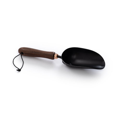 Black scoop with wooden handle on a white background