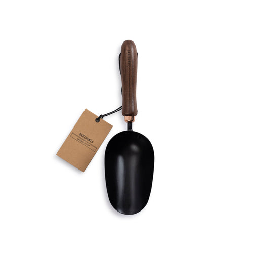 Black garden trowel with wooden handle and a brand tag on a white background